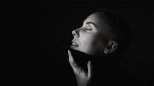 Une femme cache son double menton dans son pull