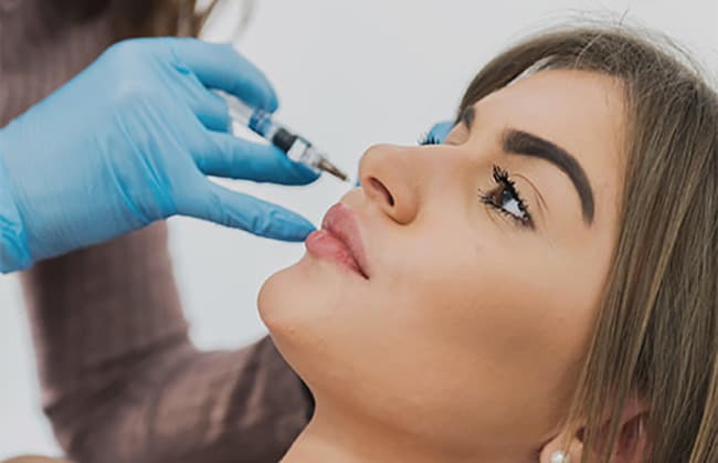 Patiente recevant une injection d'acide hyaluronique au sein du cabinet du Dr Emma Lavocat à Bordeaux