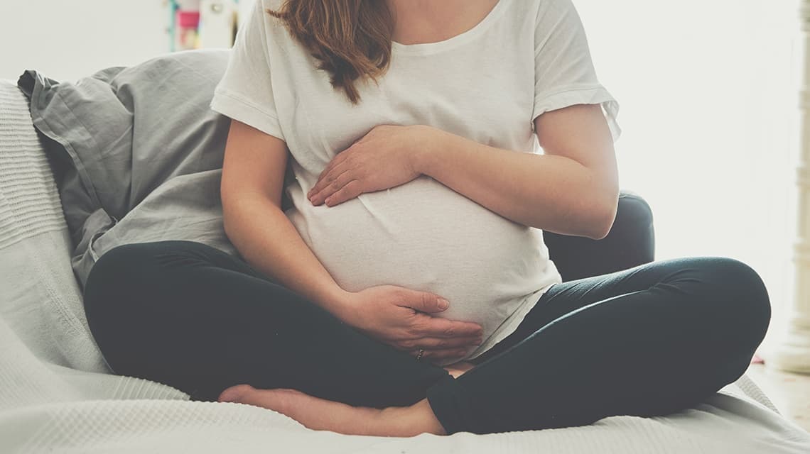 Photo d'une femme enceinte tenant son ventre à deux mains