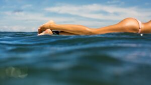 Surfeuses allongée sur sa planche aux fesses bien dessinées et peu volumineuses