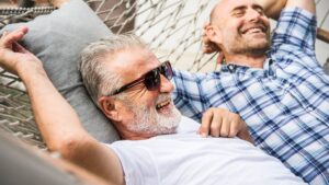 Deux hommes barbus rigolent dans un hammac