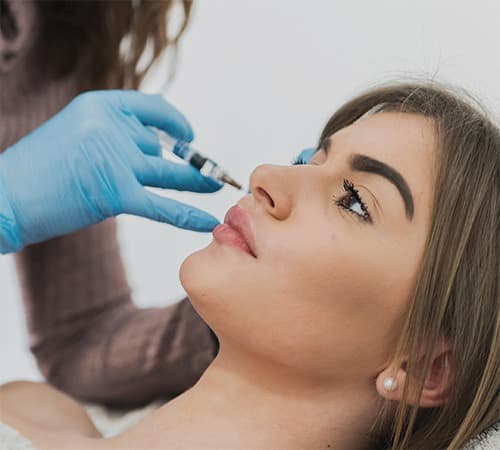 Patiente recevant une injection d'acide hyaluronique au sein du cabinet du Dr Emma Lavocat à Bordeaux